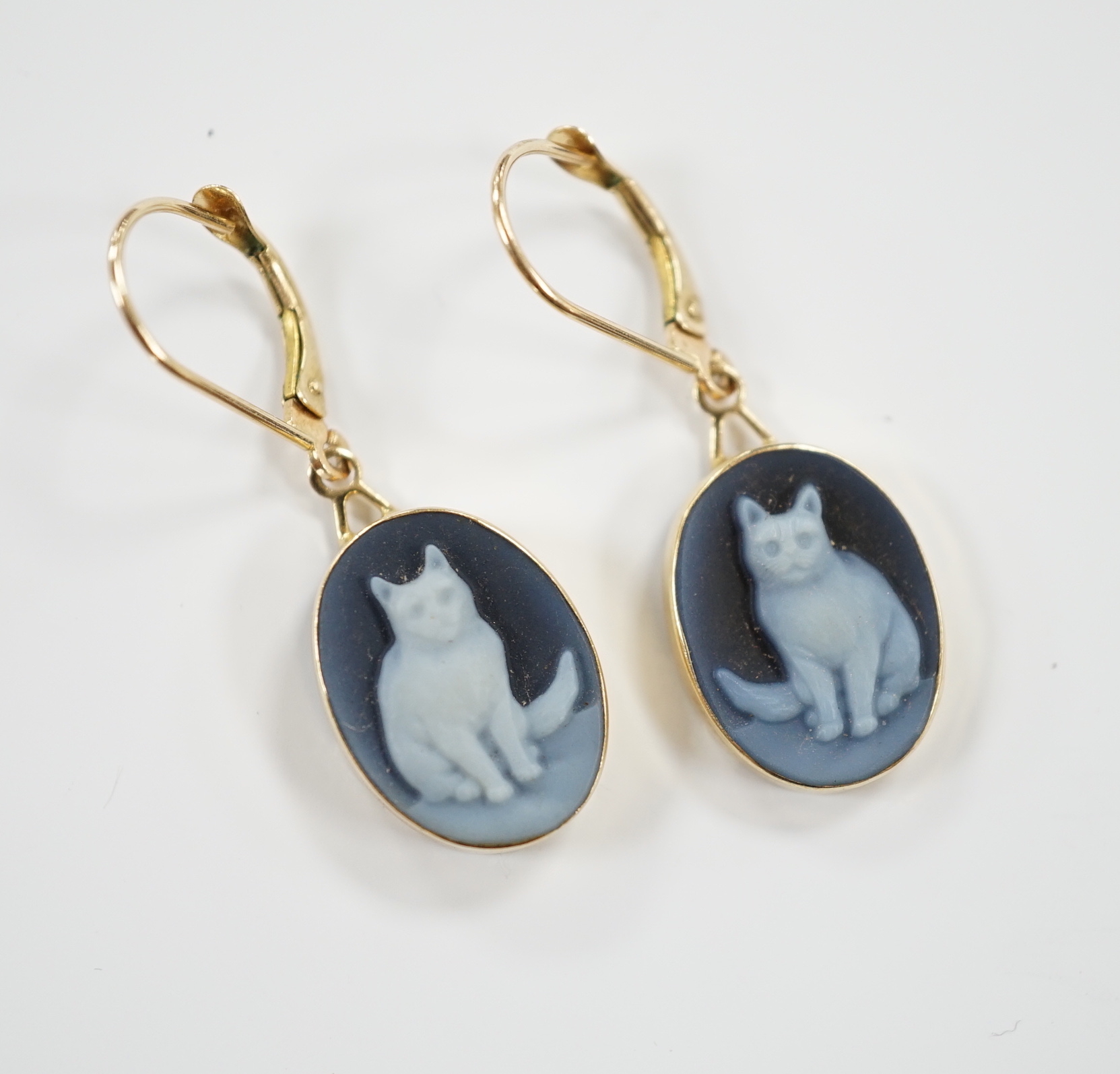 A pair of 585 yellow metal and cameo glass? set oval drop earrings, each decorated with a seated cat, overall 33mm, gross weight 3.4 grams.